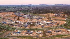 Bird's-eye view of a residential area with houses and power lines, highlighting the town's arrangement and connectivity.