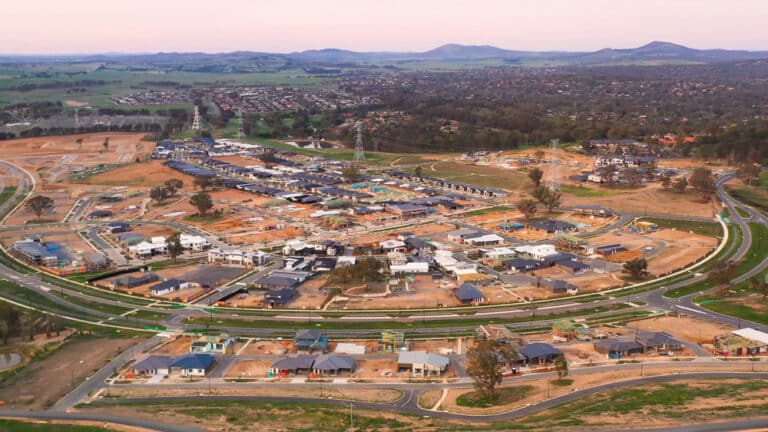 Bird's-eye view of a residential area with houses and power lines, highlighting the town's arrangement and connectivity.