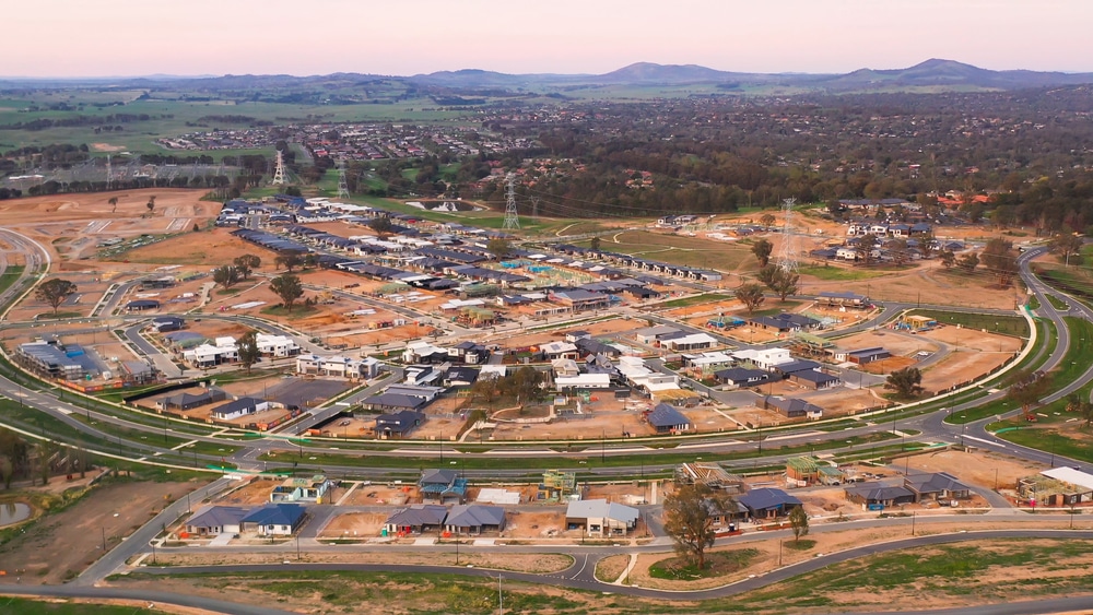 Bird's-eye view of a residential area with houses and power lines, highlighting the town's arrangement and connectivity.