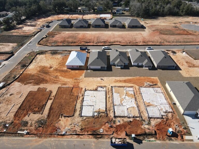 Aerial view of a construction site featuring multiple houses and vacant lots under development.