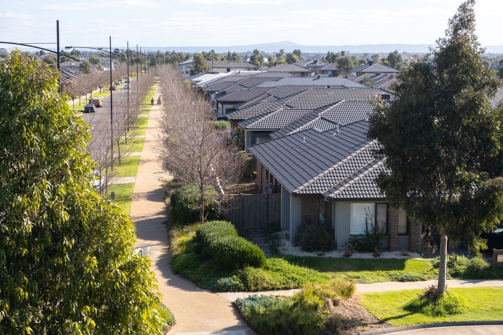 Suburban neighborhood with rows of houses, a paved pathway, and landscaping.