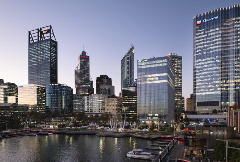 Nine The Esplanade building amongst the cityscape with several high-rise buildings near a waterfront.