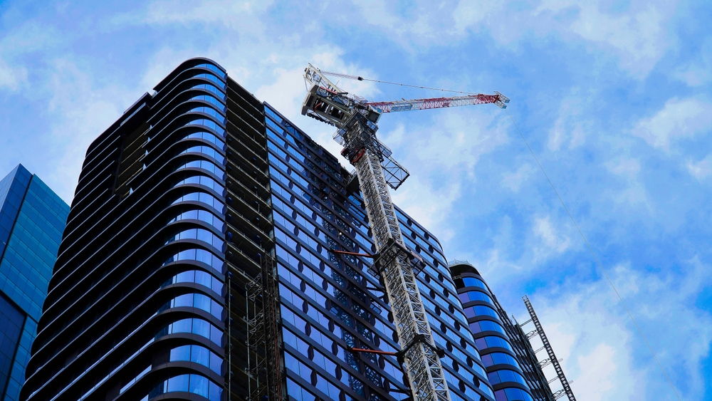 A crane is positioned atop a tall building, indicating ongoing construction or renovation work.