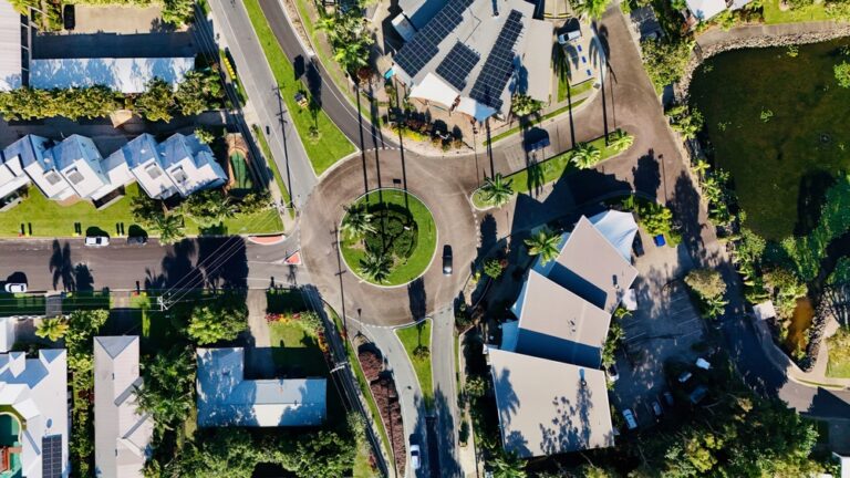 Aerial view of a residential area featuring a roundabout surrounded by houses and green spaces.
